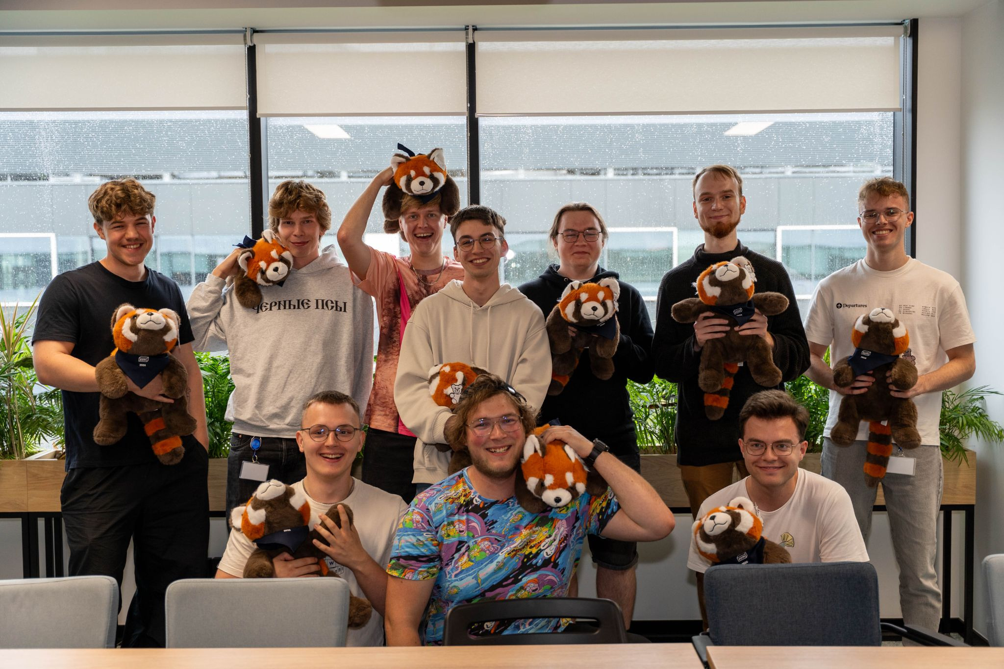 Software Mansion interns holding red panda plushies